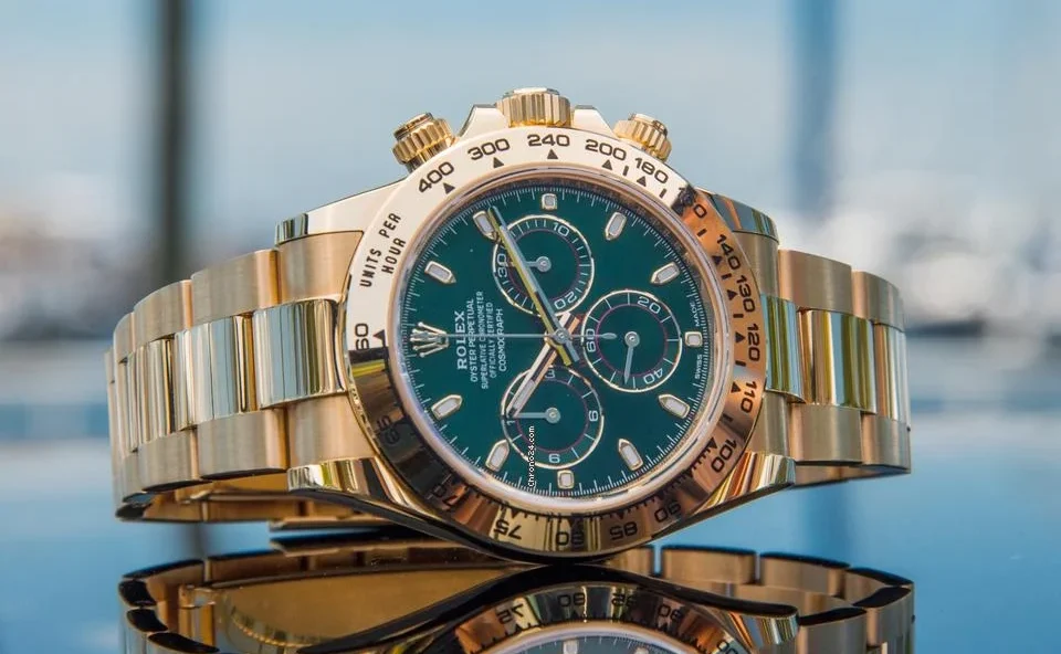 Home 7 Valutazione Rolex Oyster Perpetual 116508 Green Dial appoggiato su tavolino con sfondo sfuocato